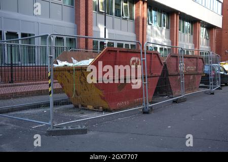 Settembre 2021 - due grandi costruttori skips piazzato sulla strada all'interno di un sicuro Heras recintato composto in una strada posteriore a Bristol, Inghilterra, Regno Unito. Foto Stock