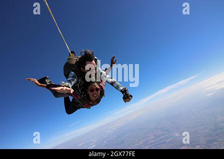 Salto in paracadute tandem. Bella donna brasiliana. Foto Stock