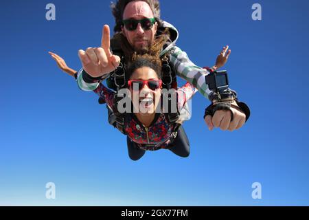 Salto in paracadute tandem. Bella donna brasiliana. Foto Stock