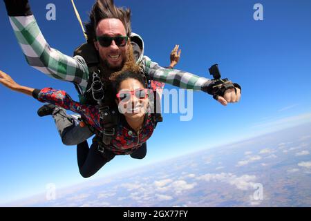 Salto in paracadute tandem. Bella donna brasiliana. Foto Stock