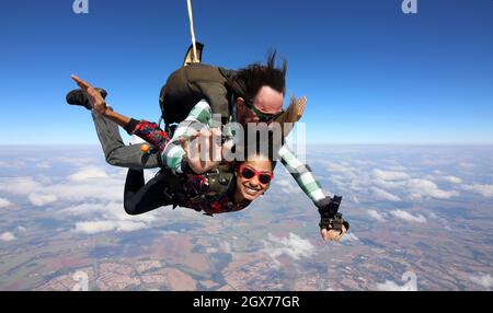 Salto in paracadute tandem. Bella donna brasiliana. Foto Stock