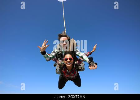 Salto in paracadute tandem. Bella donna brasiliana. Foto Stock