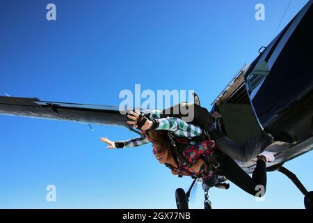 Salto in paracadute tandem. Bella donna brasiliana. Foto Stock