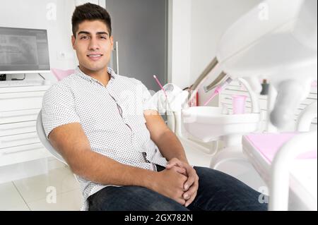 Ritratto di un paziente bello e positivo sorridendo guardando la telecamera, dopo il trattamento in clinica dentale. Foto di alta qualità. Foto Stock