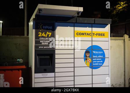 Armadietto di raccolta pacchi InPost visto di notte nel parcheggio della stazione ferroviaria di Kenley, a sud di Londra. Foto Stock
