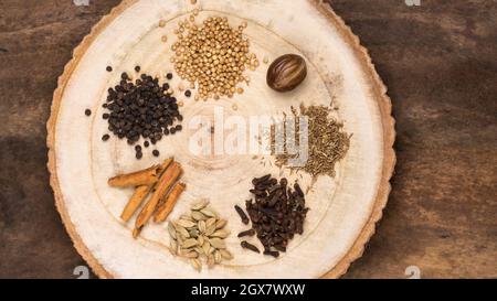 varie spezie utilizzate per la cucina, semplici ingredienti di garam masala indiani, comune miscela di spezie in cucina del sud asiatico, su una superficie di legno Foto Stock