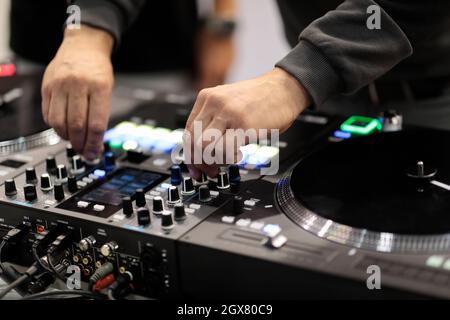 DJ mixa le tracce su un controller MIDI professionale. Messa a fuoco selettiva. Foto Stock