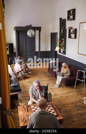 Scatto ad ampio angolo verticale di persone anziane che godono di attività in casa di cura, spazio copia Foto Stock