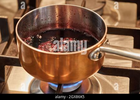 Pentola di rame a fuoco basso su stufa per fare la salsa Foto Stock