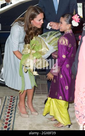 Catherine, Duchessa di Cambridge riceve un bouquet di fiori da una giovane ragazza mentre arriva con il Principe William, Duca di Cambridge per un pranzo ospitato dal primo Ministro della Malesia a Kuala Lumpur il 3° giorno di un Tour del Giubileo dei Diamanti dell'Estremo Oriente. Foto Stock