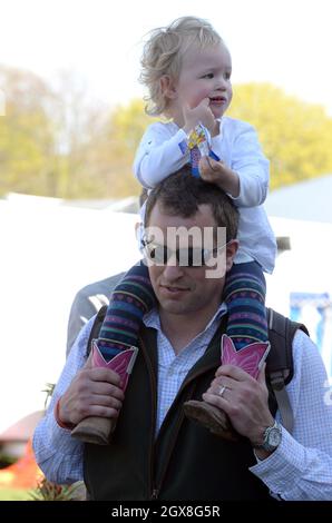 Peter Phillips porta sua figlia Savannah Phillips durante le prove a cavallo di Badminton dei motori Mitsubishi. Foto Stock