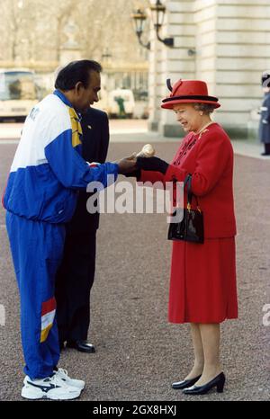 La regina consegna un batone d'argento e d'oro ad un atleta malese Datuk Punch Gunalan oggi (Lunedi) per segnalare l'inizio del relè dei Giochi del Commonwealth da Buckingham Palace a Kuala Lumpur, dove i 16 Giochi si terranno nel mese di settembre. Foto Stock