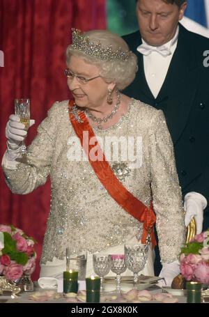 La regina Elisabetta II brinda durante un banchetto di Stato in suo onore, ospitato dal presidente francese Francois Hollande all'Elysee Palace di Parigi il 6 giugno 2014. Foto Stock