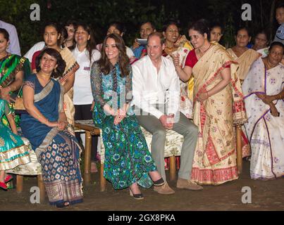 Il principe William, duca di Cambridge e Caterina, duchessa di Cambridge, indossando un abito stampato di Anna sui, guarda ballare al fuoco durante una celebrazione del Bihu Festival a Kaziranga , India il 12 aprile 2016. Foto Stock