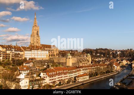 Famosa cattedrale gotica storica di Berna, con il cielo nuvoloso e il fiume Aare in una giornata di sole Foto Stock