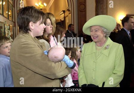 La regina britannica Elisabetta II parla con Joanna Fryatt con il suo bambino di 10 settimane Bailey durante la sua visita alla base navale di Devonport, Plymouth, lunedì 24 marzo 2003. Il marito della signora Fryatt, Niky, sta servendo con la RAF in uno Squadrone come un gunner. La Regina incontrò famiglie di coloro che servivano nel Golfo, dove chiacchierò con decine di mogli, figli, madri e padri. Anche il duca di Edimburgo, giunto separatamente, trascorse del tempo a parlare con le famiglie. Mezza lunghezza, cappello, re, sorridente, bambini Â Anwar Hussein/allaction.co.uk Foto Stock