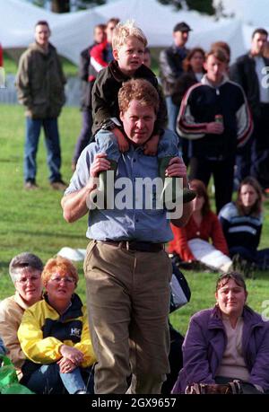 Charles, Earl Spencer con suo figlio Louis sulle spalle, cammina tra le folle assistendo al concerto tributo a sua sorella Diana, Principessa di Galles, ad Althorp la casa di famiglia. Â Anwar Hussein/allactiondigital.com Foto Stock