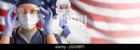 Medici o infermieri che indossano dispositivi di protezione individuale (DPI) per uso medico contro la bandiera americana Banner. Foto Stock