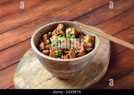 Tofu dolce, piccante, croccante e fritto in salsa teriyaki. Cibo vegano sano, senza glutine Foto Stock