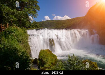 Cascata nella bellissima natura con acqua cristallina sul fiume selvaggio n.a. in Bosnia e Erzegovina al giorno d'estate e di sole Foto Stock