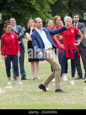 Il Prince William, Duke of Cambridge, è stato il 13 luglio 2017 a giocare a calcio con la squadra di calcio femminile inglese e i giovani giocatori del programma di calcio Wildcats Girls nei giardini di Kensington Palace Foto Stock