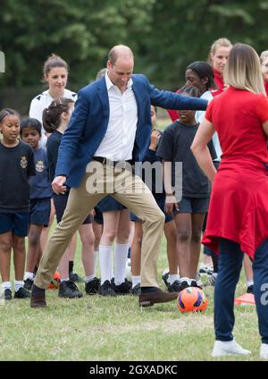 Il Prince William, Duke of Cambridge, è stato il 13 luglio 2017 a giocare a calcio con la squadra di calcio femminile inglese e i giovani giocatori del programma di calcio Wildcats Girls nei giardini di Kensington Palace Foto Stock