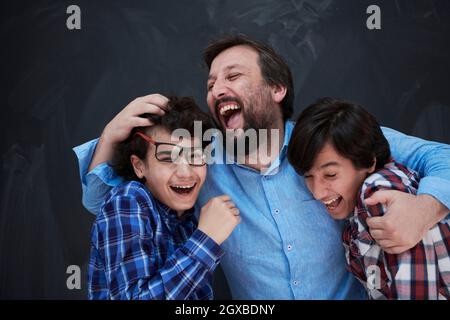 felice padre abbracciare figli momenti indimenticabili di gioia di famiglia in gara mista medio orientale famiglia araba Foto Stock