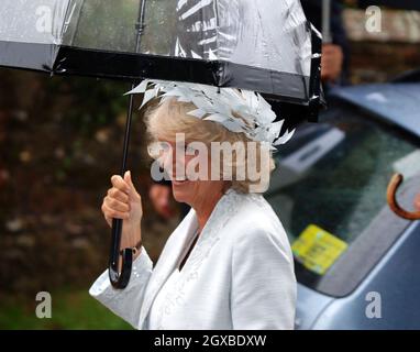 Camilla, Duchessa di Cornovaglia, ripara sotto un ombrello come lei arriva per il matrimonio di suo figlio, Tom Parker-Bowles, a Sara acquista presso la Chiesa di San Nicola a Henley-on-Thames, Inghilterra. Anwar Hussein/allactiondigital.com Foto Stock