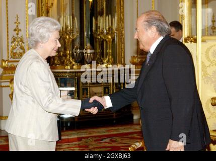 La Regina Elisabetta II della Gran Bretagna incontra il presidente della FIFA Sepp Blatter durante un ricevimento a Buckingham Palace a Londra per celebrare il centenario del corpo di governo del gioco in tutto il mondo. Â Anwar Hussein/allactiondigital.com Foto Stock