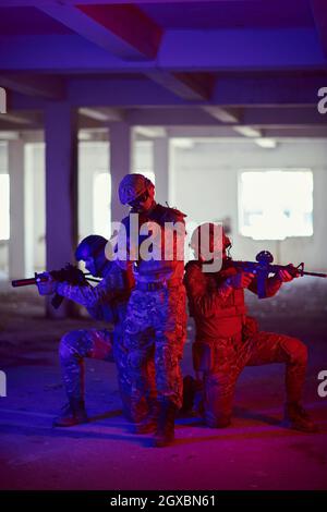 i soldati della guerra moderna squadra in formazione tattica hanno azione urbano ambiente illuminazione colorata Foto Stock