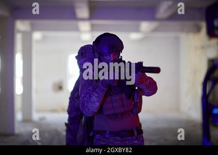 i soldati della guerra moderna squadra in formazione tattica hanno azione urbano ambiente illuminazione colorata Foto Stock