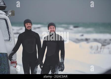 Autentici surfisti artici locali in muta dopo il surf in mare norvegese in minivan. Isole Lofoten scandinave Foto Stock