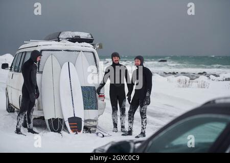 Autentici surfisti artici locali in muta dopo il surf in mare norvegese in minivan. Isole Lofoten scandinave Foto Stock