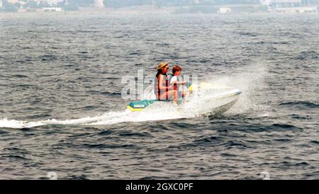 Diana, Principessa del Galles, indossando un costume da bagno, corre con il principe Harry su un jet ski nel 1996 al largo della costa del sud della Francia. Anwar Hussein/EMPICS Entertainment Foto Stock