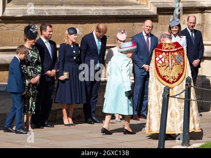 La regina Elisabetta ll è accolta dai membri della famiglia (l a r) James, Visconte Severn, Sophie, Contessa di Wessex, Peter Phillips, Autunno Phillips, Principe Harry, Duca del Sussex, ZaraTindall, Mike Tindall, Caterina, Duchessa di Cambridge e il Principe William, Duca di Cambridge, mentre frequenta il servizio del giorno di Pasqua alla Cappella di San Giorgio a Windsor Foto Stock