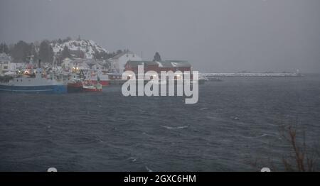 Cabine e barche tradizionali norvegesi di pescatori, sull'isola di Lofoten, nel nord della Norvegia. Stagione invernale maltempo Foto Stock