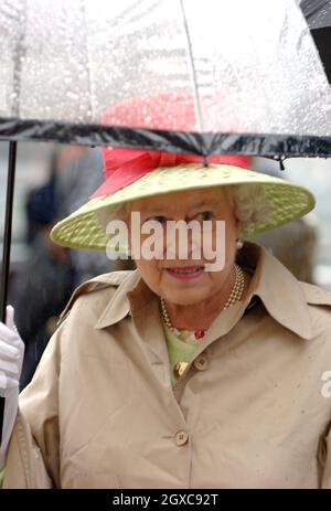 La regina Elisabetta II si ripara sotto un ombrello mentre arriva per il pranzo ai Giardini d'Inverno a Weston-super-Mare il 20 luglio 2007. Foto Stock