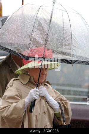 La regina Elisabetta II si ripara sotto un ombrello mentre arriva per il pranzo ai Giardini d'Inverno a Weston-super-Mare il 20 luglio 2007. Foto Stock
