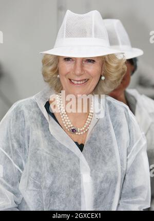 Camilla, duchessa di Cornovaglia, offre un cappello protettivo, un cappotto e delle pantofole durante una visita per aprire la nuova panetteria Marshfield a Tolldown, Wiltshire. Foto Stock