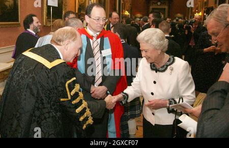 La Regina Elisabetta II scuote le mani con Lord Kinnock dopo aver presentato i Premi per l'anniversario della Regina per l'istruzione superiore e superiore. Foto Stock