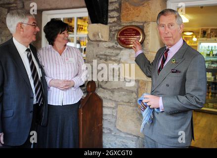 Prince Charles, Prince of Wales svela una targa nel negozio del villaggio come Louise Dinnes, proprietario del pub, ristorante, hotel e bar Black Swan guarda, 31 marzo 2008 a Ravenstonedale, Cumbria, Inghilterra. Il Principe è stato in visita come parte dell'iniziativa 'il Pub del Principe è l'hub' per sostenere e promuovere le comunità rurali. Foto Stock