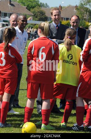 Il principe William, presidente della Football Association, e il giocatore di Aston Villa Ashley Young incontrano giovani calciatori durante la sua visita al campo da calcio del Kingshurst Sporting FC, West Midlands Foto Stock