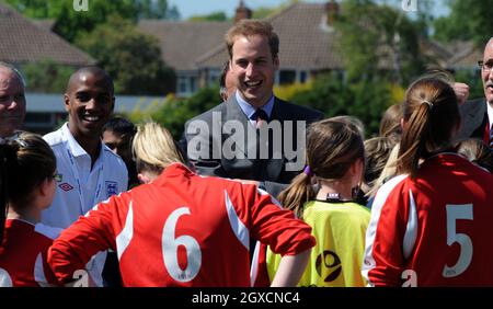 Il principe William, presidente della Football Association e il giocatore di Aston Villa Ashley Young incontrano giovani calciatori durante la sua visita al campo da calcio del Kingshurst Sporting FC, West Midlands Foto Stock