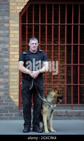 Una guardia carceraria e un cane di guardia sono visti fuori Belmarsh (prigione HM) nel sud-est di Londra Foto Stock