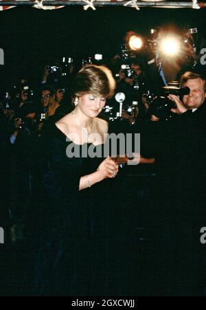 **FOTO DEL FILE** Lady Diana Spencer, in seguito diventata Diana, Principessa del Galles, imposta i flashbulbi che spuntano mentre indossa un vestito nero Emanuel rivelante partecipando al suo primo fidanzamento ufficiale con il Principe Carlo ad un concerto di raccolta fondi presso la Goldsmiths Hall di Londra nel marzo 1981. I designer Elizabeth e David Emanuel hanno in mano un'asta di abiti indossati dalla compiuta principessa Diana. Gli abiti saranno destinati all'asta l'8 giugno 2010 a Londra, presso le aste specializzate di moda d'epoca Kerry Taylor Auctions. Foto Stock