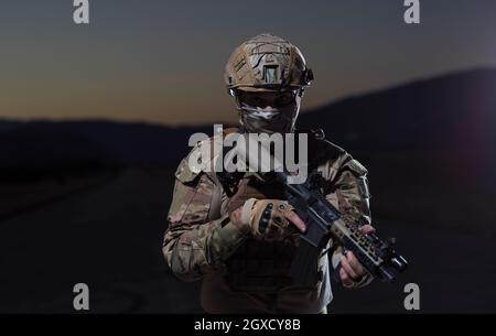 soldato con arma e completo equoment militare e attrezzatura da combattimento in missione notturna Foto Stock