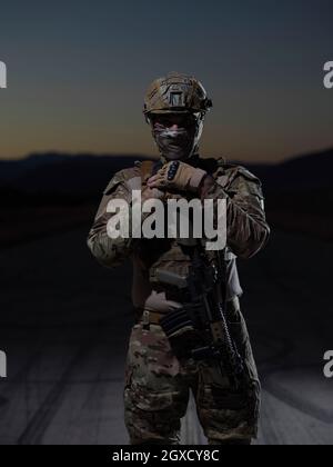 soldato con arma e completo equoment militare e attrezzatura da combattimento in missione notturna Foto Stock