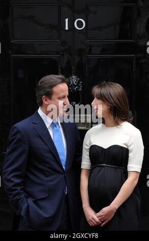 Il primo ministro David Cameron e sua moglie Samantha aspettano di salutare il presidente francese Nicolas Sarkozy e sua moglie Carla al 10 di Downing Street Foto Stock