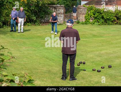 Inglese Crown Green bocce. Un gruppo di uomini anziani che si godono una partita di bocce sui prati medievali di Lewes, East Sussex, Inghilterra. Foto Stock