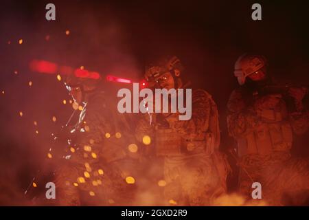 i soldati si sono schierati in azione in missione notturna utilizzando il concetto di squadra militare di luci laser a raggi di vista Foto Stock